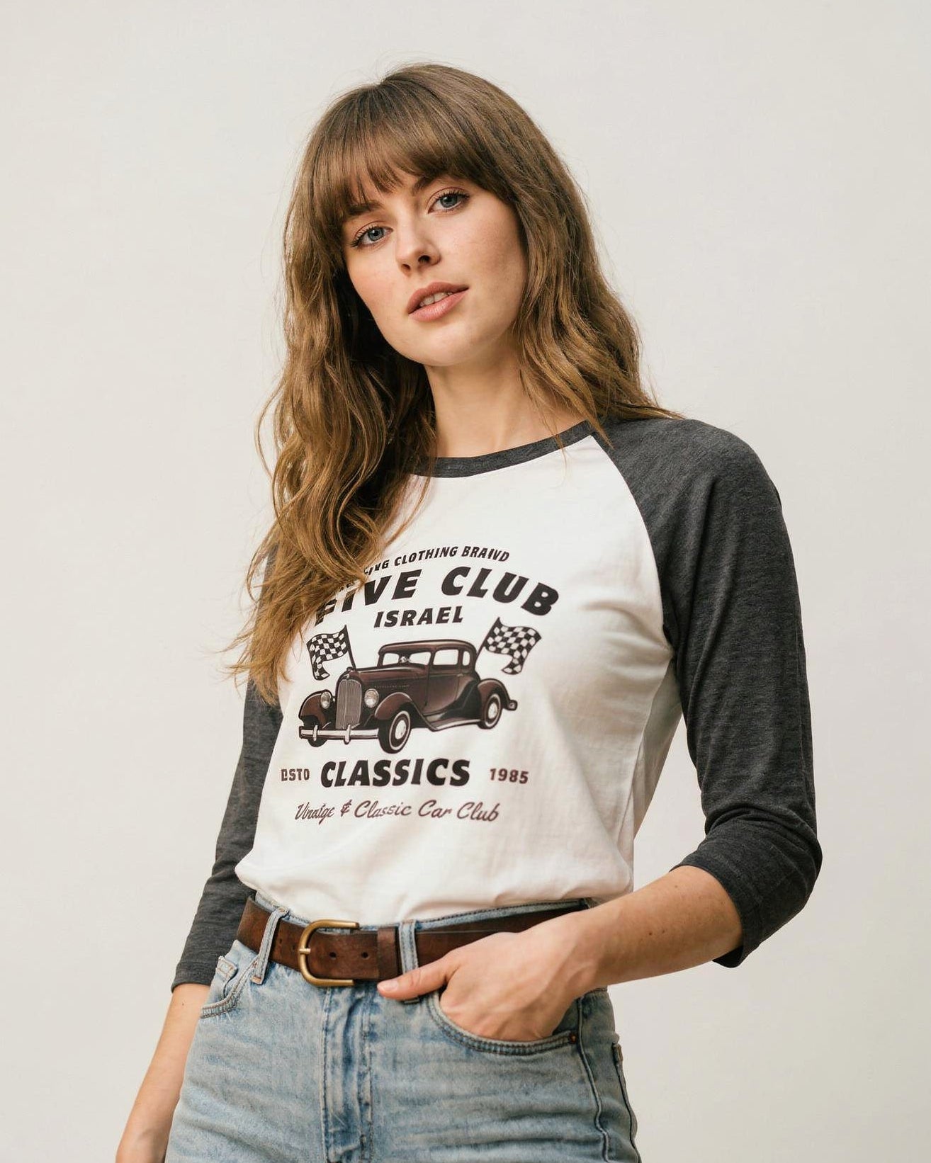 Woman wearing a baseball tee with a graphic design on a plain background