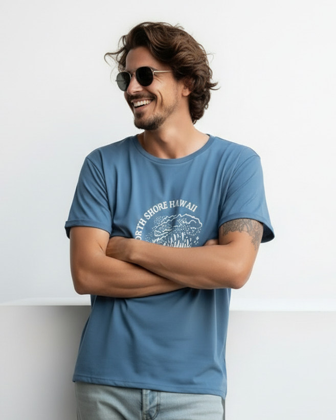 Man wearing a blue t-shirt with a graphic design, standing against a white background