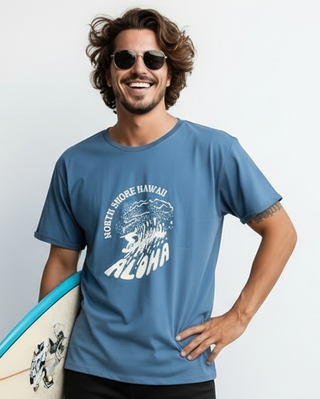 Man holding a surfboard wearing a blue t-shirt with a graphic design on a white background