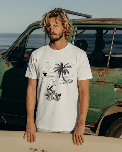 Man holding a surfboard with a vintage van and ocean in the background