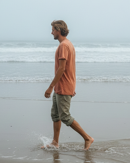 Man walking along a beach with a minimalistic background