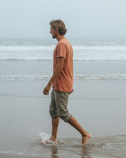 Man walking along a beach with a minimalistic background