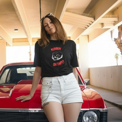 Person leaning against a red vintage car in an indoor parking garage.