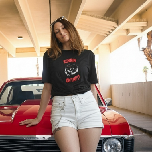 Person leaning against a red vintage car in an indoor parking garage.