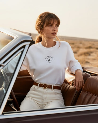 Woman sitting in a vintage car in a desert setting