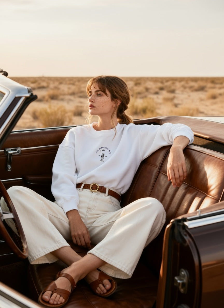 Woman sitting in an open-top car in a desert setting