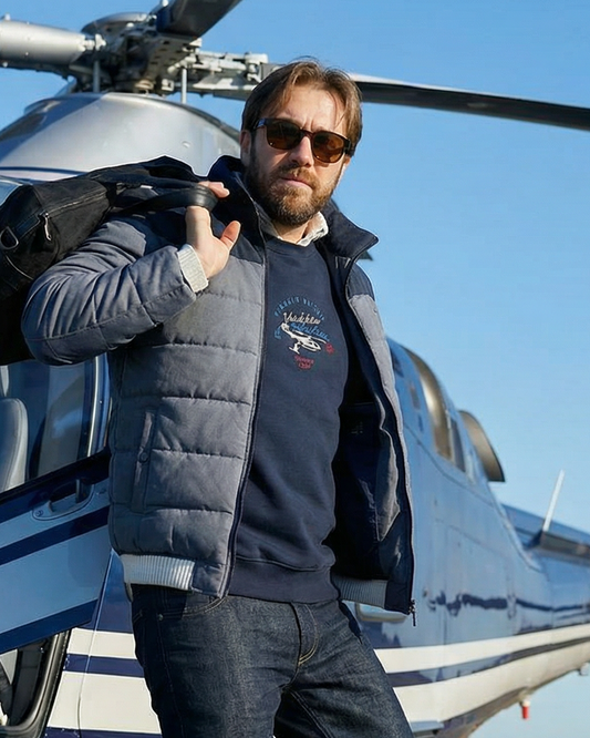 Man standing next to a helicopter on a clear day