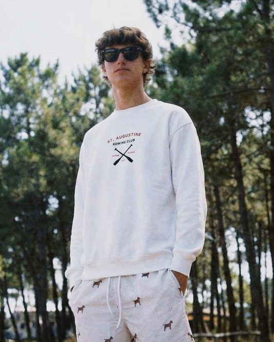 Person wearing a white sweatshirt and shorts with a forest background
