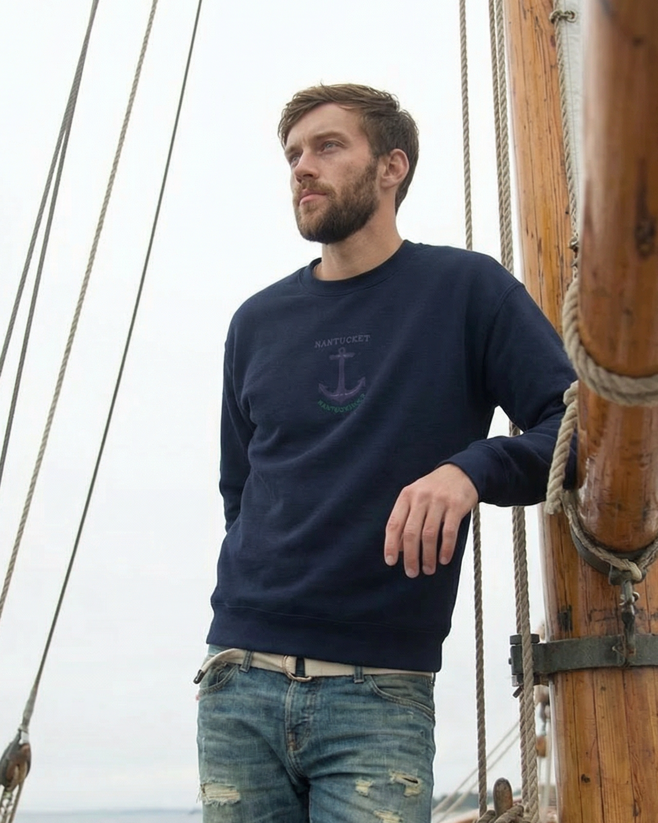 Man standing on a ship with wooden rigging and ropes