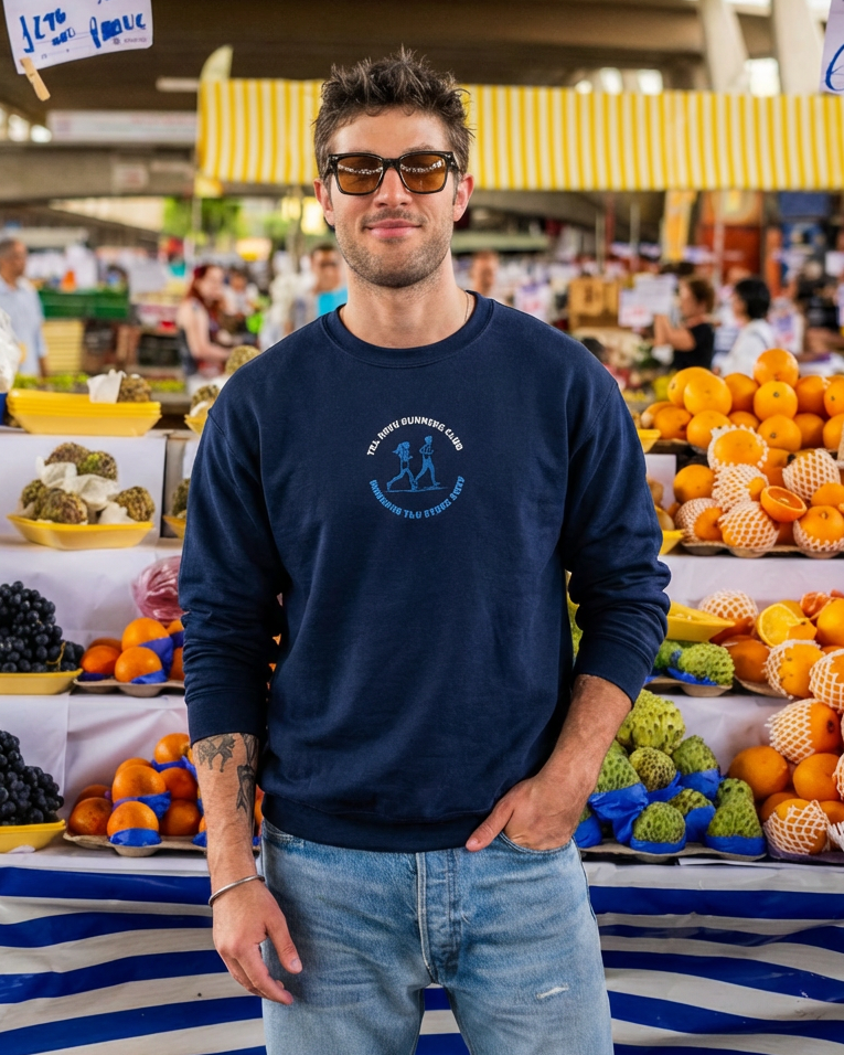 Man wearing sunglasses and a navy sweatshirt with a logo at an outdoor market.
