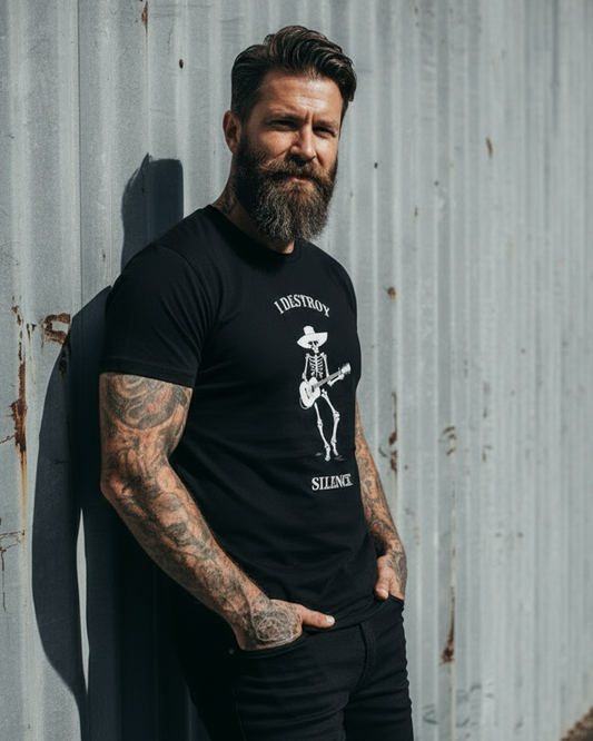 Man wearing a black t-shirt with a graphic design, standing against a textured wall.