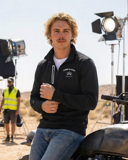 Person sitting on a motorcycle on a film set with filming equipment in the background