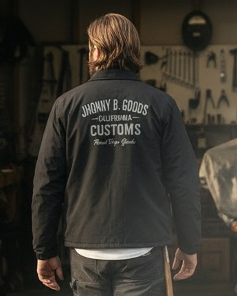 Person walking into a garage wearing a branded jacket.