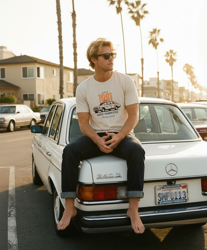 Man sitting on a classic Mercedes-Benz car with palm trees in the background